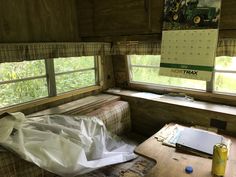 a room with a couch, table and calendar on the window sill in it