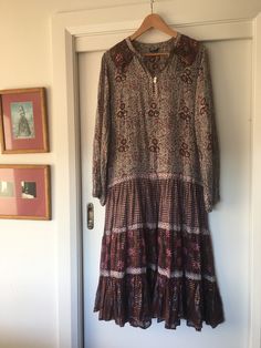 Vintage Indian cotton dress. Beautiful stamped floral pattern in pink, brown and purple shot through with gold threads. Tagged a large but please use the measurements below as a guide. Measured flat please double where applicable  Bust 19 inch Waist 19 inch Shoulders (measured across the back) 14 inch Hips 19 inch Length (collar to hem) 43 inch Arm length (shoulder to cuff) 24 inch Dress is in an excellent condition with no holes or stains noted. Elastic still present in cuffs however it's lost most of its stretch. Happy to provide further information or images.  Dress is from a smoke and pet free home and has been carefully stored. Long Brown Floral Print Dress, Long Brown Dress With Floral Print, Indian Cotton Dress, Vintage Indian, Indian Cotton, Gold Threads, Pink Brown, Dress Beautiful, Dress Clothes For Women