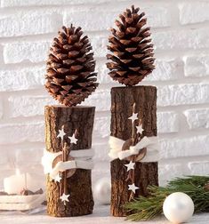 two pine cones decorated with white stars and ribbons