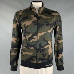 Valentino Spa Jacket In A Green And Brown Cotton Blend Fabric Featuring All Over Camo Pattern, Two Pockets, Ribbed Cuffs, And A Zip Up Closure. Made In Italy.Excellent Pre-Owned Condition. Marked: Xl Measurements: Shoulder: 21.5 Inches Chest: 45 Inches Sleeve: 25.5 Inches Length: 26.5 Inches Sui Generis Reference: 127382 Category: Jacket More Details Brand: Valentino Chest Size: Xl Size: Xl Gender: Male Color: Green Color 2: Brown Pattern: Camo Fabric: Polyamide / Cotton Style: Zip Up Made In: I Valentino Jacket, Valentino Camo Jacekt, Fitted Camouflage Military Outerwear, Military Camouflage Utility Jacket With Multiple Pockets, Camouflage Military Outerwear With Pockets, Military Camouflage Hooded Jacket For Outdoor, Cotton Jacket, Cotton Style, Green And Brown