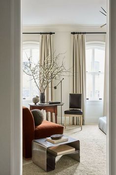 a living room filled with furniture and a chandelier hanging from the ceiling next to a window