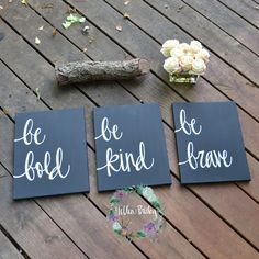 three wooden signs that say be kind of brave and be kind of brave with flowers in the background