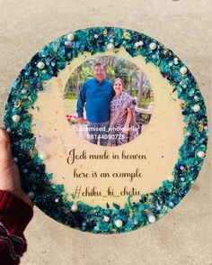 a person holding up a plaque with an image of two people in the center and words on it