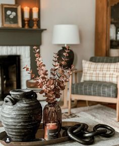 a living room filled with furniture and a vase on top of a tray next to a fire place