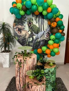 a balloon arch is decorated with green, orange and black balloons in the shape of animals