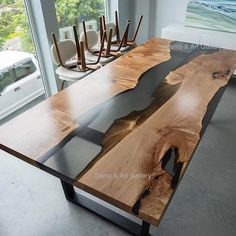 a table made out of wood and glass in front of a window with chairs behind it