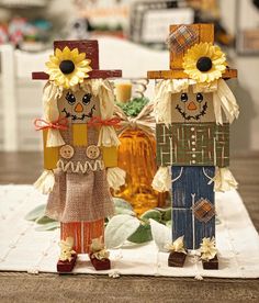 two scarecrows are standing next to each other on a table with bottles in the background