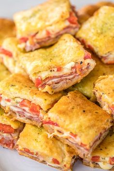 a pile of food sitting on top of a white plate covered in cheese and meat