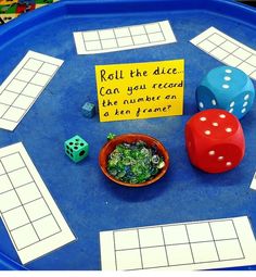 a blue tray topped with dices and paper on top of it's sides