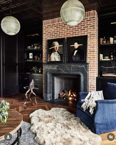 a living room filled with furniture and a fire place in front of a brick fireplace