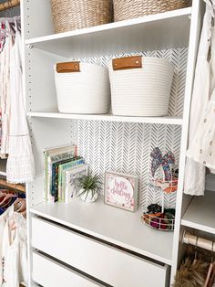 an organized closet with baskets, books and other items on shelving unit shelves in white