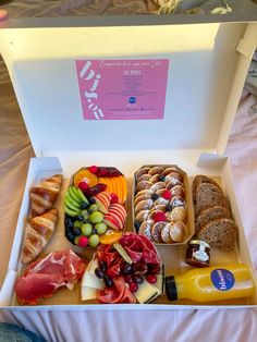 an open box filled with different types of food on top of a white tablecloth