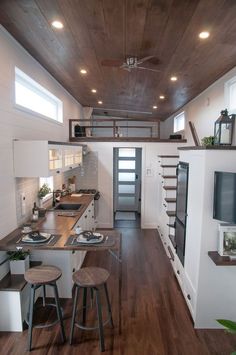 an instagramted photo of a tiny house with wood flooring and white walls