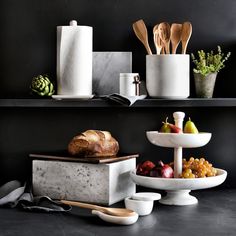 there are many different types of food on the shelves in this kitchen, including bread and fruit