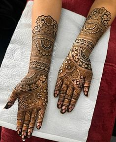 two hands with henna tattoos on them