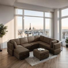 a living room with large windows and a sectional couch in front of a city view