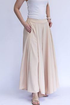 Be the talk of every room with our Keep it Glowing - Woven Wide Leg Pants! These champagne, satin pants are beyond gorgeous. They give the illusion of a skirt, but bring the comfort of pants. This item has a high waist, elastic waist band, and pockets. We love these so much because you can throw on a blouse to dress them up, or a tank to dress them down. You can wear these for any occasion and be the most stylish gal in the room! - Champagne colored woven wide leg pants - High waist - Elastic wa Beige Maxi Skirt With Elastic Waistband, Elegant Full Length Bottoms With Wide Waistband, Beige High Waist Harem Pants With Elastic Waistband, Elegant Stretch Harem Pants With Elastic Waistband, Elegant Wide Leg Bottoms With Wide Waistband, Elegant High-waisted Harem Pants For Spring, Wide-leg Bottoms With Wide Waistband, Chic Wide Leg Bottoms With Waistband, Elegant Harem Pants With Elastic Waistband