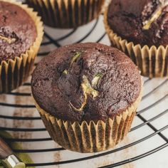 chocolate muffins cooling on a wire rack with green sprouts in the middle