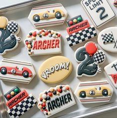 decorated cookies in the shape of race cars and racing numbers are displayed on a tray