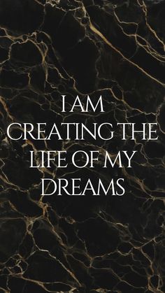 the words i am creating the life of my dreams written in white on a black marble background