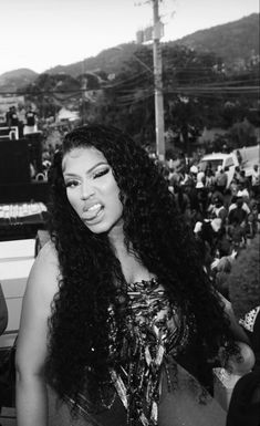 a woman with long hair standing in front of a crowd