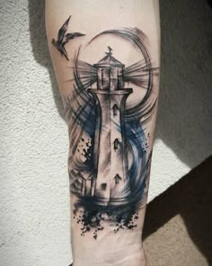 a black and white lighthouse tattoo on the right arm with birds flying around it,