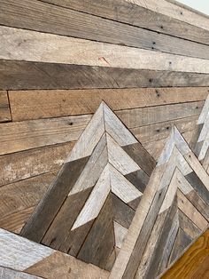 the wood has been cut into triangles and placed on top of each other to make a wall decoration