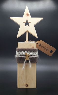 a wooden star on top of a small box with a tag hanging from it's side