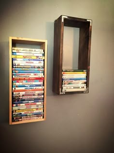 a wooden box with dvd's in it is next to a wall mounted mirror