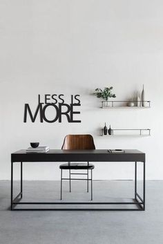 a black table and some shelves in a white room with the words less is more on it