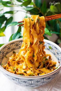 chopsticks holding up noodles in a bowl