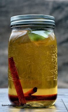 a jar filled with liquid sitting on top of a wooden table