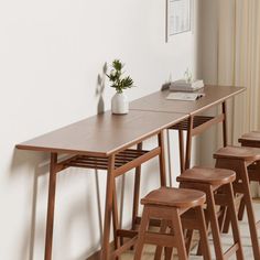 a long table with four stools next to it and a potted plant on top