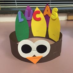 a paper crown made to look like an owl with the word lucas written on it