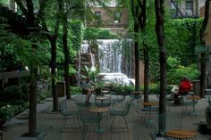 people sitting at tables near a waterfall