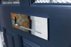 a close up of the handles on a blue door with an orange and white pattern