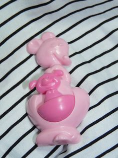 a pink toy car sitting on top of a black and white striped sheet with stripes