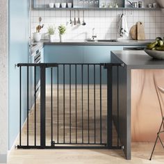 a kitchen with blue walls and white tile on the floor, has a black gate that opens up to let in more light into the room