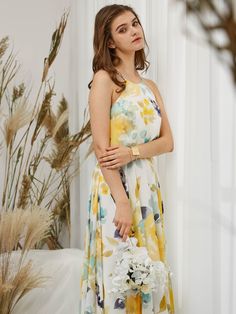 a woman in a yellow and white floral print dress holding a flower bouquet with her right hand