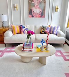 a living room filled with furniture and a painting on the wall above it's coffee table