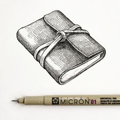 an ink drawing of a book with a bow on it's cover, next to a marker