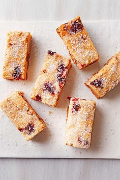 several pieces of cake sitting on top of a white cutting board