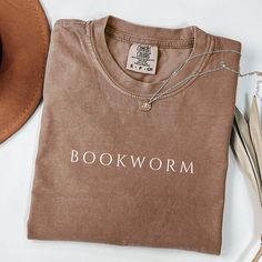 This cozy and stylish tee is perfect for any book lover who wants to wear their passion proudly. Whether you're a librarian, teacher, or just love to get lost in a good story, this shirt is for you. The Comfort Colors fabric ensures a soft, comfortable fit, making it the ideal choice for long reading sessions. It's also a thoughtful gift for the bookworm in your life or a fellow reader who enjoys expressing their love for literature. Embrace your inner book lover with this classic, bookish shirt Bookish Tees, Club Tshirt, The Bookworm, Bookworm Shirt, Book Shirt, Librarian Shirt, Reading Shirts, Gifts For Bookworms, Book Shirts