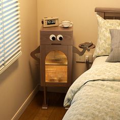 a bed room with a neatly made bed and an alarm clock on the night stand