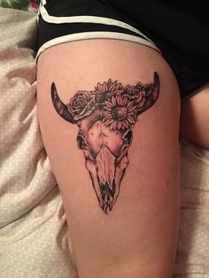 a cow skull with sunflowers on it's side and the lower thigh