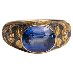 A stunning faceted, oval blue kyanite center gemstone in a sterling silver ring with 18K gold overlay in a floral and vine motif. Two round diamonds create the center of the two flowers on the sides. Ring size is an 8. The fine jewelry collection is sourced, designed or created by Deborah Lockhart Phillips. Through her international travels, she has cultivated prime resources for fine precious and semi-precious gemstones of unusual cuts in a variety of settings. Included in the collection are an Unusual Rings 1stdibs, Heirloom Oval Sapphire Ring With Gemstone Accents, Oval Engraved Sapphire Ring For Formal Occasions, Heirloom Oval Engraved Sapphire Ring, Heirloom Sapphire Ring With Gemstone Accents For Formal Occasions, Gold Overlay, Blue Kyanite, Gold Piece, Fine Jewelry Collection