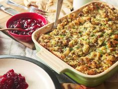 a casserole dish with stuffing and cranberry sauce on the side next to it