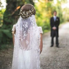 a bride and groom walking down a path in the woods with their back to the camera