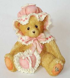 a brown teddy bear wearing a pink and white outfit