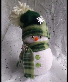 a green and white snowman wearing a hat and scarf